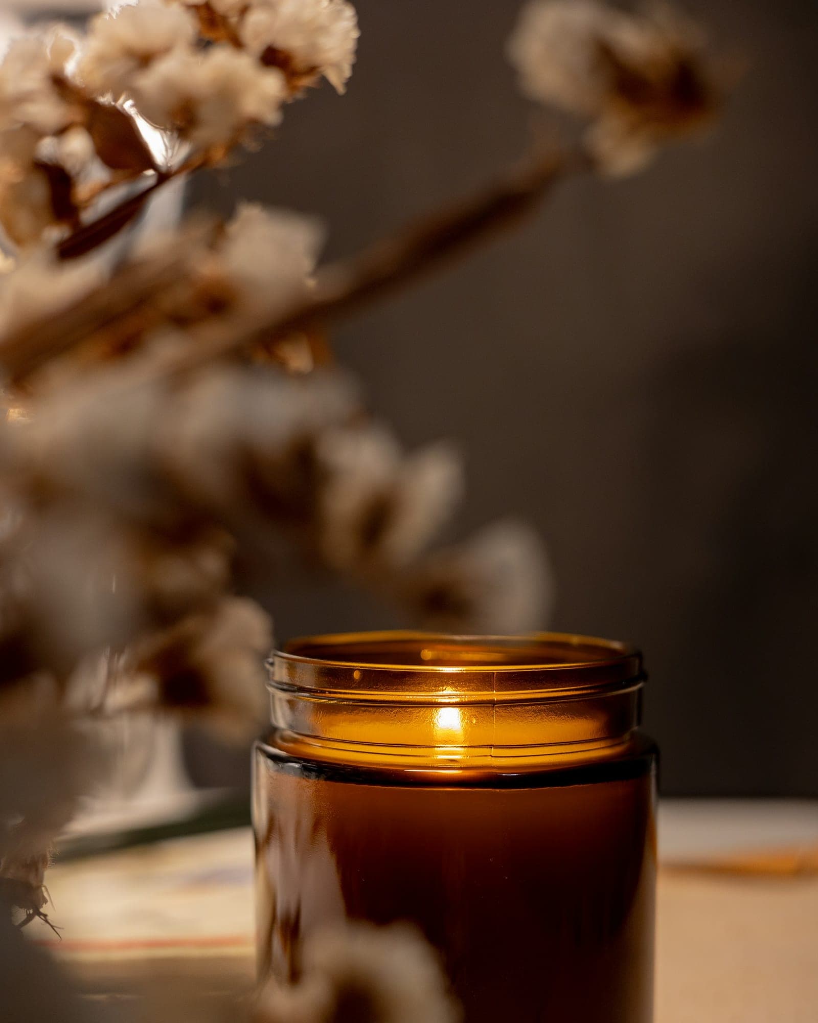 Lit candle in an amber glass jar