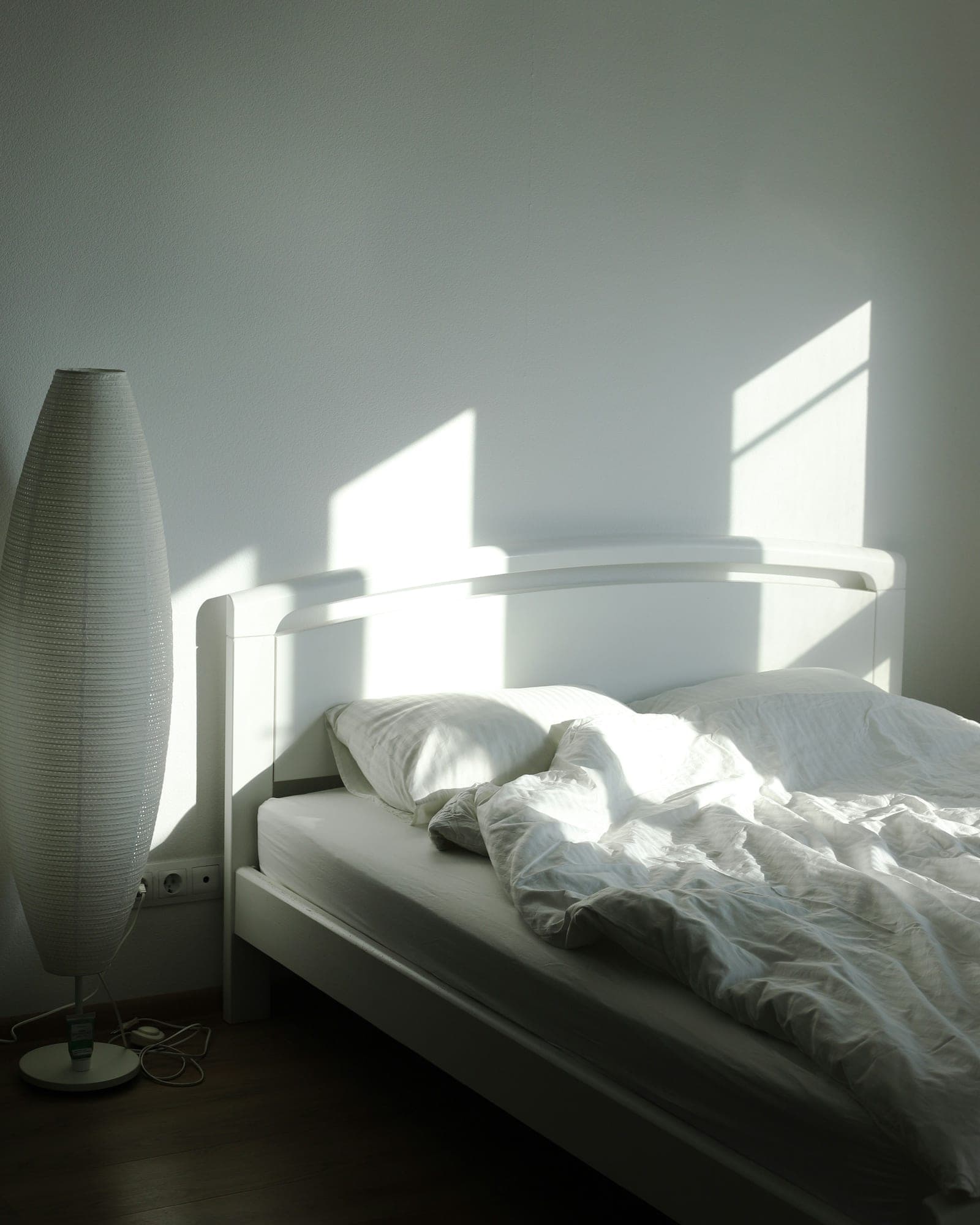 White duvet on a bed in early morning sunlight