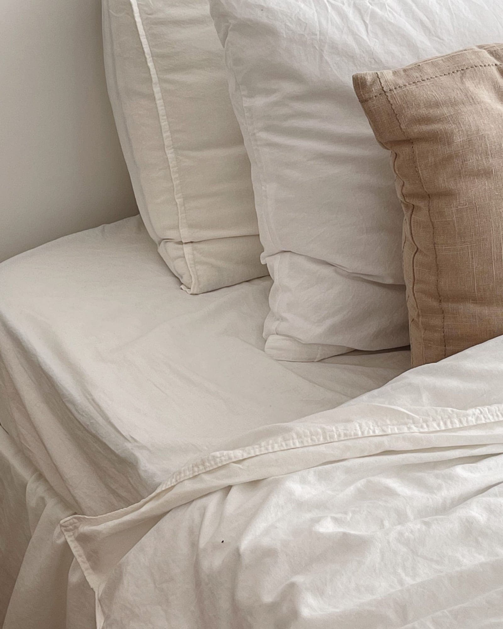 Ivory cotton pillowcases on a freshly made bed