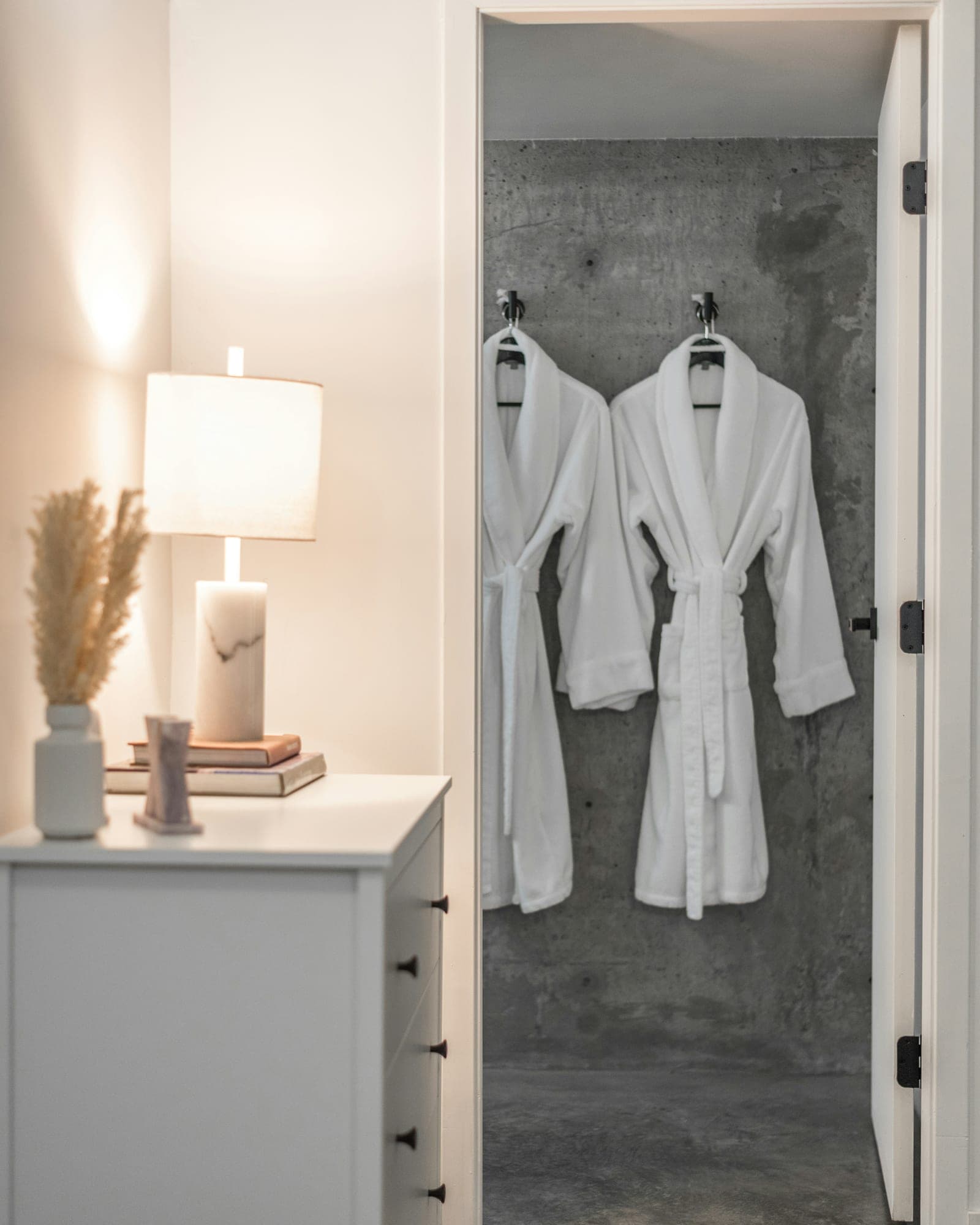 White bathrobes hanging in a guest bathroom